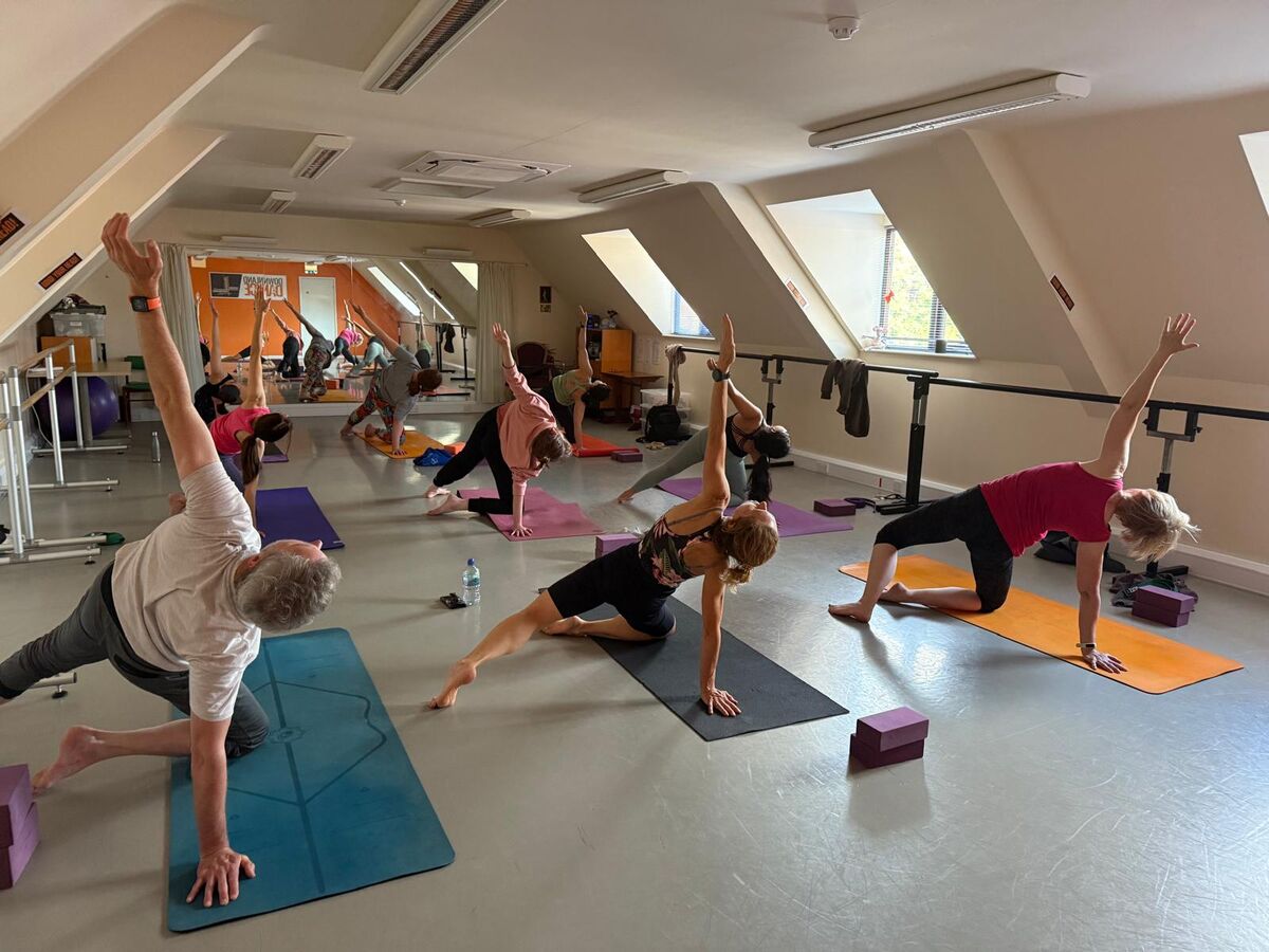 People practicing Vinyasa Yoga in a sunny studio in Abingdon
